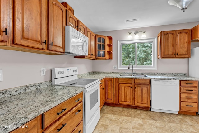 9209 Topoco Dr, Knoxville, TN 37922 - kitchen with white appliances, brown cabinets, light stone countertops, and glass insert cabinets