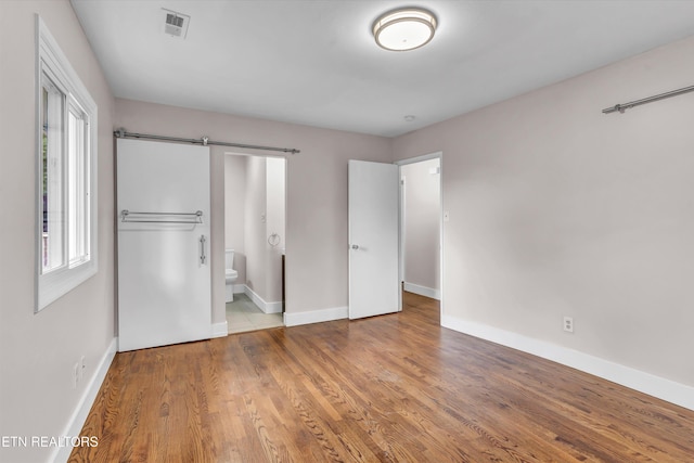 9209 Topoco Dr, Knoxville, TN 37922 - unfurnished bedroom with multiple windows, wood finished floors, and connected bathroom