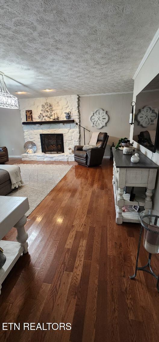 1922 Chaney Ridge Rd, London, KY 40741 - living area with a textured ceiling, wood finished floors, a fireplace, and ornamental molding