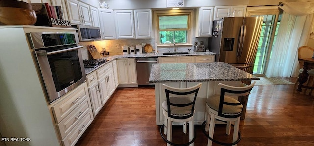 1922 Chaney Ridge Rd, London, KY 40741 - kitchen with stainless steel appliances, a sink, dark wood-style floors, white cabinets, and a kitchen island