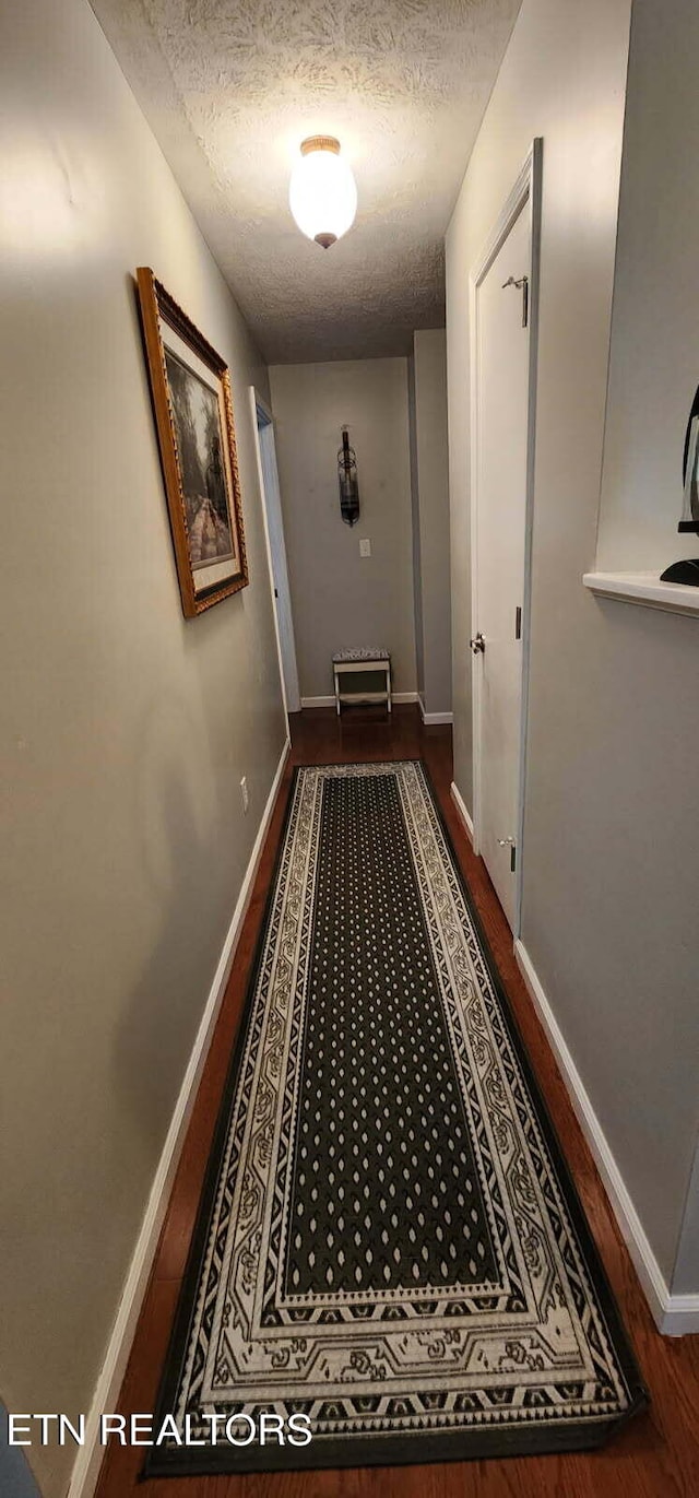 1922 Chaney Ridge Rd, London, KY 40741 - hallway featuring a textured ceiling, baseboards, and dark wood-type flooring