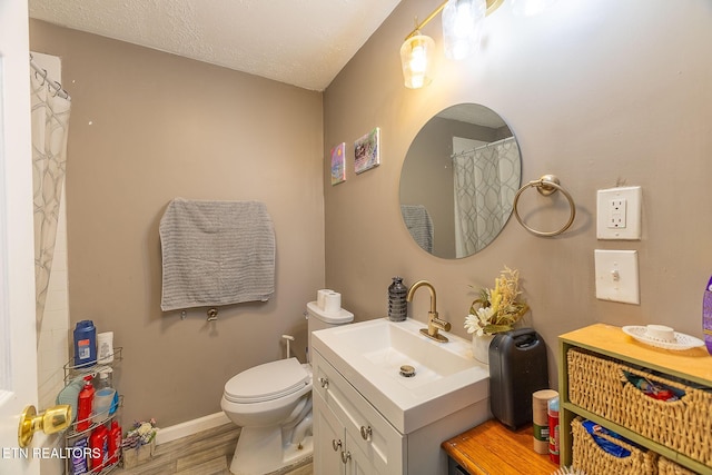 902 Rosedale Ave, Loudon, TN 37774 - full bath with vanity, wood finished floors, toilet, a textured ceiling, and baseboards