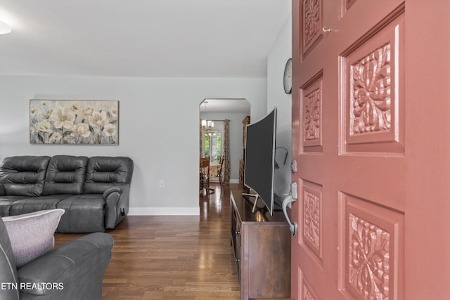 1670 Bowen Rd, Rutledge, TN 37861 - living room featuring arched walkways, dark wood-type flooring, a chandelier, and baseboards