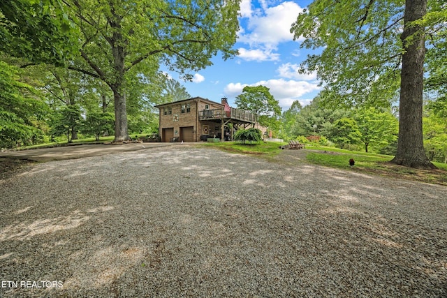 2059 Bolestown Loop, Alpine, TN 38543 - view of front of property with gravel driveway, a garage, a chimney, and a wooden deck