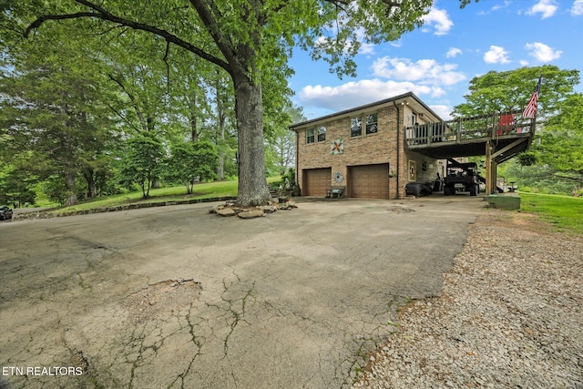 2059 Bolestown Loop, Alpine, TN 38543 - view of side of home featuring asphalt driveway, a deck, a garage, and brick siding