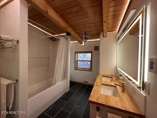 1015 Kizzy Patch Way, Del Rio, TN 37727 - bathroom with wooden ceiling with exposed beams, double vanity, tile patterned flooring, shower / bath combination with curtain, and baseboards