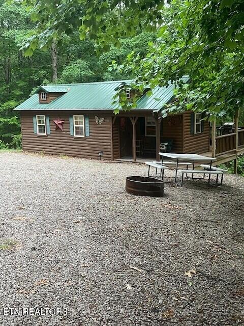 533 Valley Ridge Rd, Jamestown, TN 38556 - back of house featuring faux log siding, metal roof, and gravel driveway