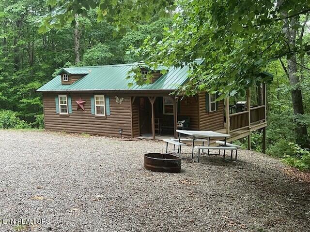533 Valley Ridge Rd, Jamestown, TN 38556 - rear view of house featuring faux log siding, an outdoor fire pit, driveway, and metal roof