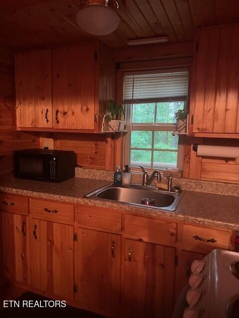 533 Valley Ridge Rd, Jamestown, TN 38556 - kitchen featuring black microwave, a sink, wood ceiling, wood walls, and light countertops