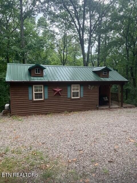533 Valley Ridge Rd, Jamestown, TN 38556 - view of side of home featuring metal roof, faux log siding, a porch, and view of wooded area