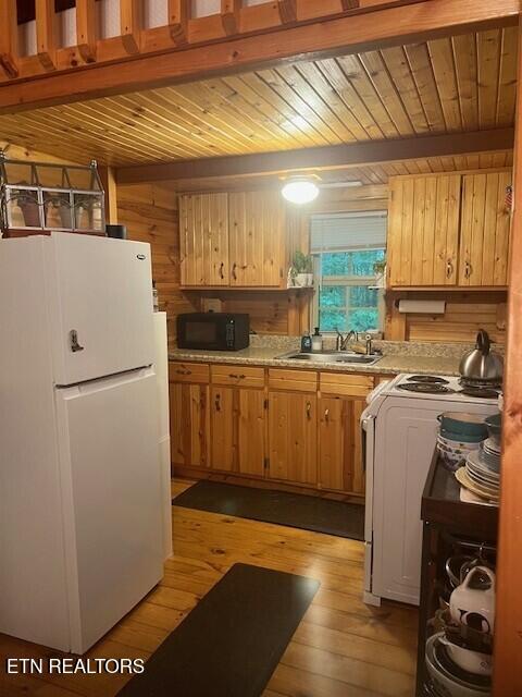 533 Valley Ridge Rd, Jamestown, TN 38556 - kitchen featuring freestanding refrigerator, black microwave, stove, wood ceiling with exposed beams, and a sink