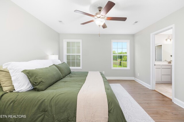 8104 Equinox Ln, Powell, TN 37849 - bedroom featuring wood finished floors, baseboards, ensuite bathroom, a ceiling fan, and a sink