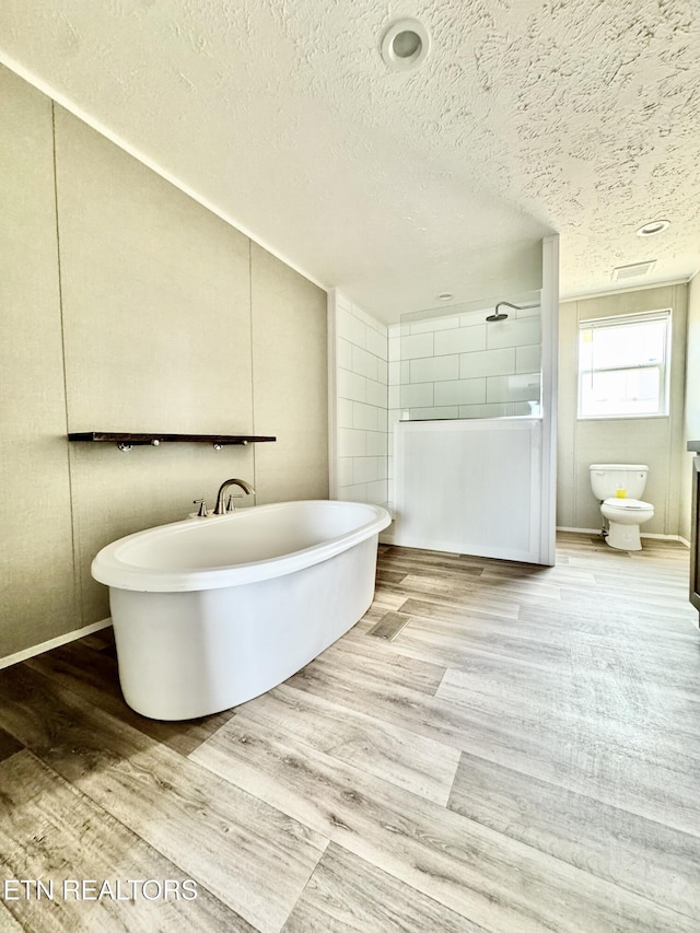 320 Perkey Way, Tazewell, TN 37879 - bathroom with wood finished floors, a freestanding bath, a textured ceiling, a shower, and toilet