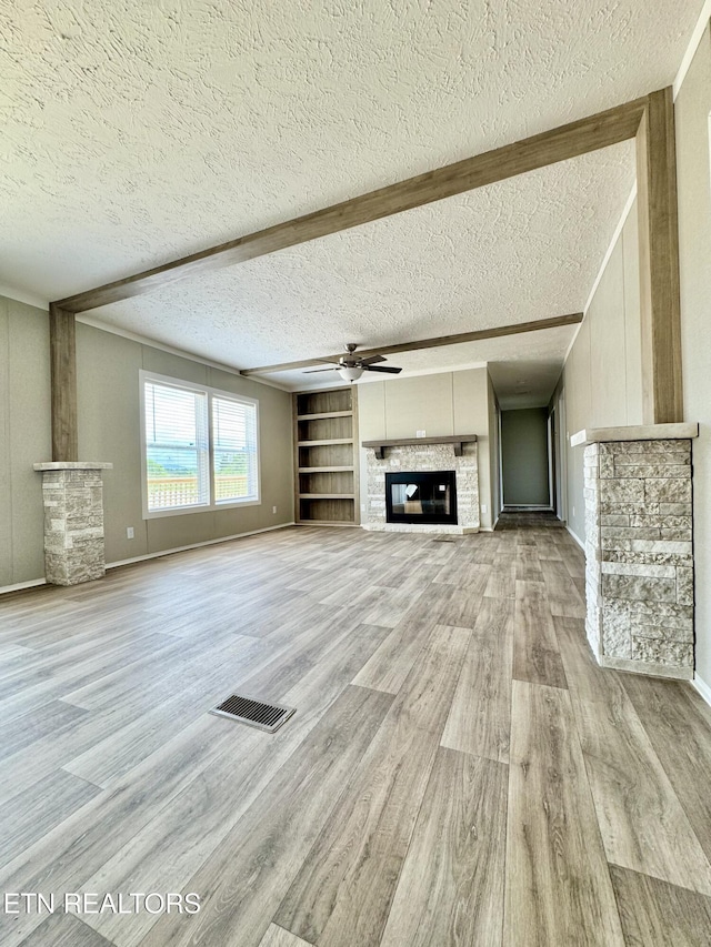 320 Perkey Way, Tazewell, TN 37879 - unfurnished living room featuring a glass covered fireplace, light wood-style floors, a textured ceiling, a ceiling fan, and baseboards