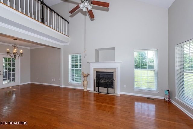 9100 Sway Branch Ln, Knoxville, TN 37922 - unfurnished living room featuring a towering ceiling, a chandelier, a fireplace with flush hearth, wood finished floors, and a ceiling fan