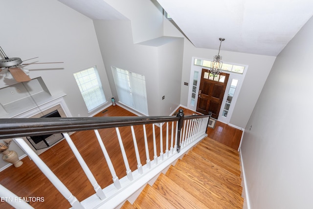 9100 Sway Branch Ln, Knoxville, TN 37922 - foyer with light wood-type flooring, high vaulted ceiling, a fireplace, a chandelier, and stairs