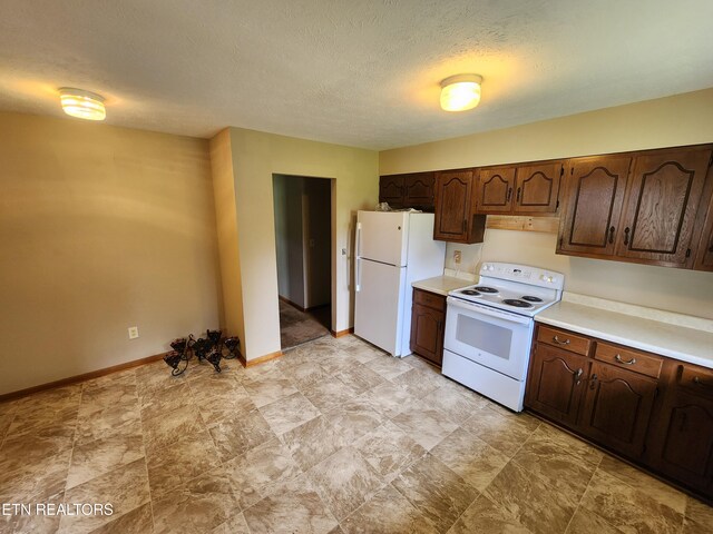 232 Kimberly Rd, Lafollette, TN 37766 - kitchen featuring white appliances, light countertops, dark brown cabinetry, baseboards, and a textured ceiling