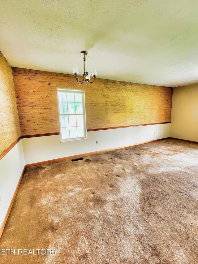 232 Kimberly Rd, Lafollette, TN 37766 - empty room with a chandelier, carpet floors, baseboards, and a textured ceiling