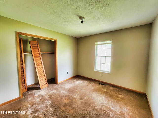 232 Kimberly Rd, Lafollette, TN 37766 - unfurnished bedroom with carpet, a closet, baseboards, and a textured ceiling
