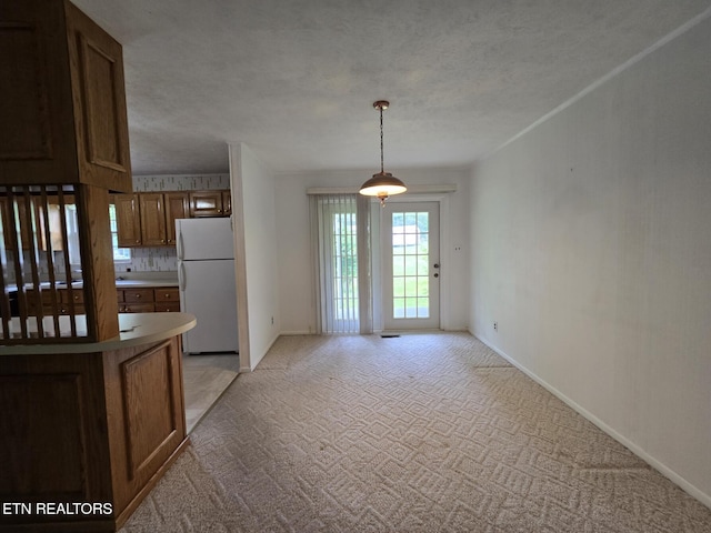 114 Verdun Rd, Oneida, TN 37841 - kitchen featuring freestanding refrigerator, light carpet, brown cabinets, a textured ceiling, and baseboards