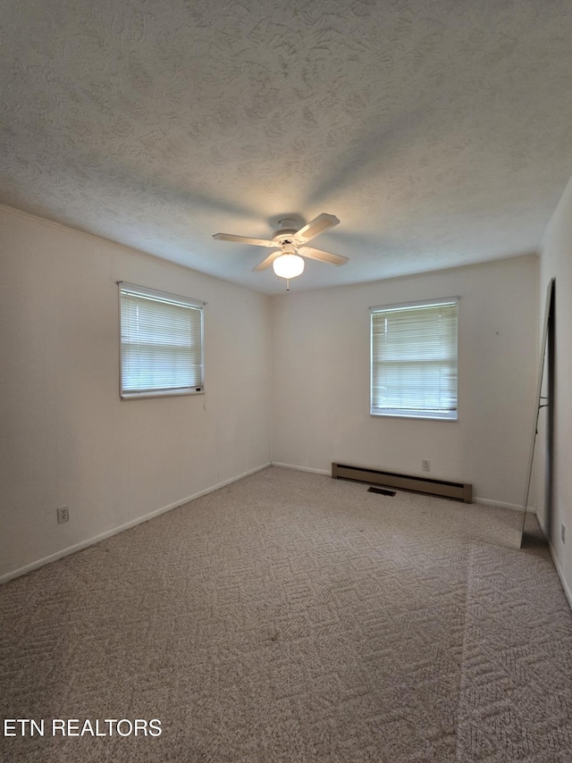 114 Verdun Rd, Oneida, TN 37841 - carpeted spare room featuring healthy amount of natural light, ceiling fan, a baseboard radiator, baseboards, and a textured ceiling