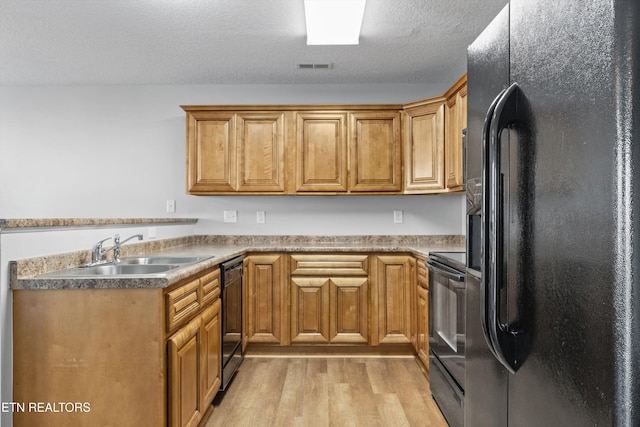203 Bar Tall Way, Seymour, TN 37865 - kitchen with black appliances, light wood finished floors, a peninsula, brown cabinets, and a textured ceiling