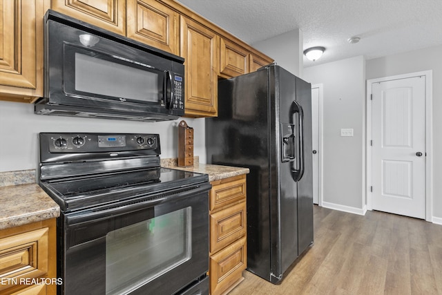 203 Bar Tall Way, Seymour, TN 37865 - kitchen featuring black appliances, wood finished floors, brown cabinets, and a textured ceiling