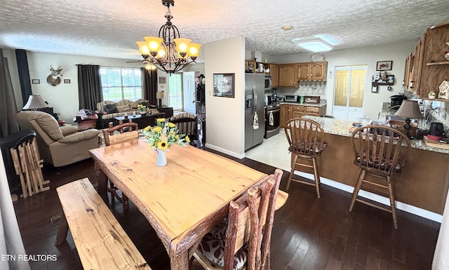 2726 Kentwood Dr, Kodak, TN 37764 - dining room featuring a chandelier, a textured ceiling, light wood finished floors, and baseboards