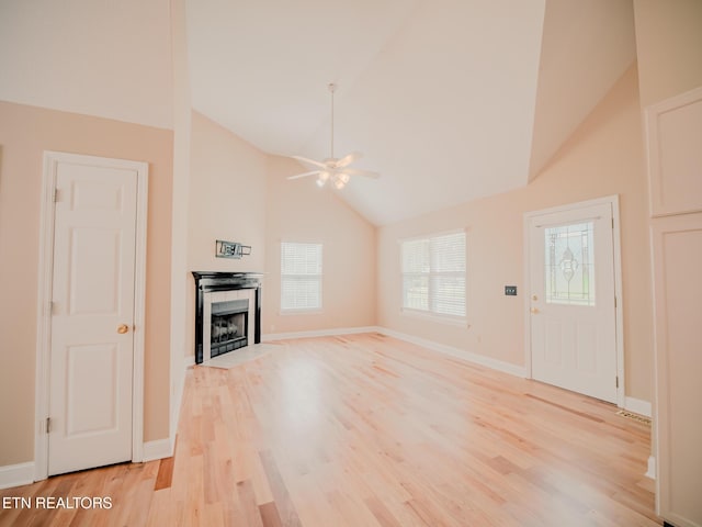 116 Deer Path Trl, Vonore, TN 37885 - unfurnished living room featuring a ceiling fan, light wood-style floors, a tiled fireplace, baseboards, and high vaulted ceiling