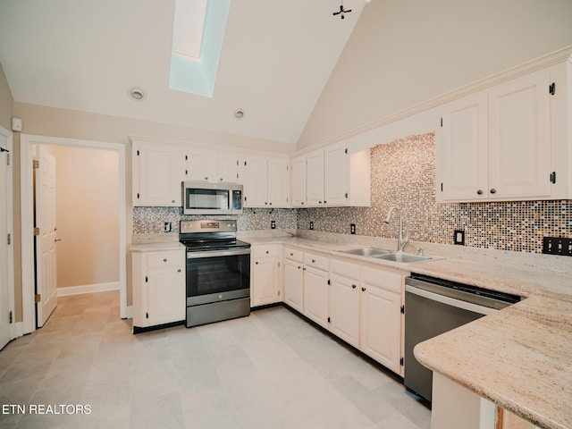 116 Deer Path Trl, Vonore, TN 37885 - kitchen with stainless steel appliances, a sink, a skylight, decorative backsplash, and light stone countertops