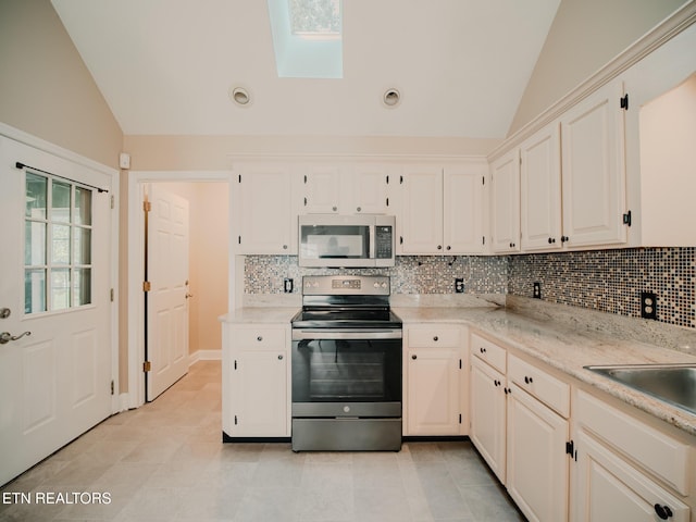 116 Deer Path Trl, Vonore, TN 37885 - kitchen featuring stainless steel appliances, vaulted ceiling, decorative backsplash, a skylight, and light tile patterned flooring
