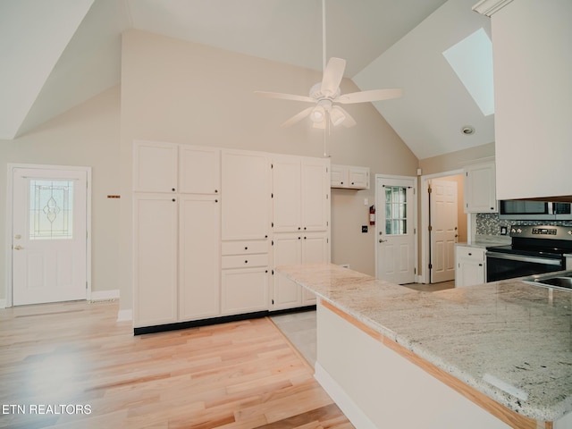 116 Deer Path Trl, Vonore, TN 37885 - kitchen with electric range, stainless steel microwave, high vaulted ceiling, white cabinets, and light stone counters