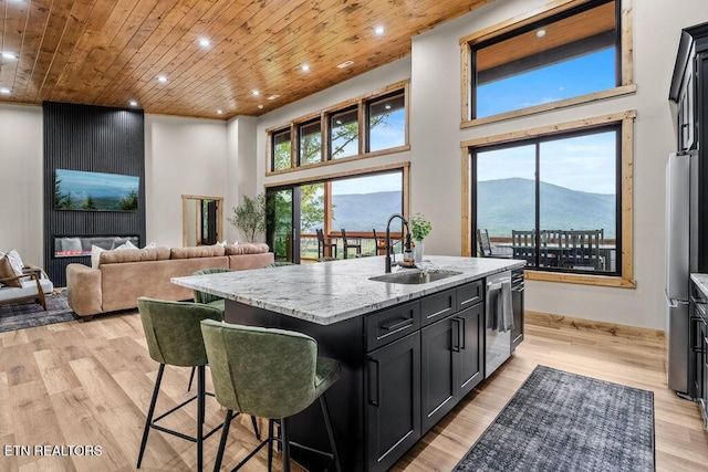 2634 Whipoorwill Hill Way, Sevierville, TN 37862 - kitchen with dark cabinets, recessed lighting, a center island with sink, light stone counters, and a breakfast bar