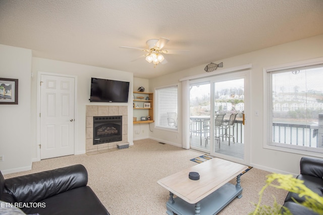 245 Doe Ln Unit 5, Lafollette, TN 37766 - carpeted living area with a ceiling fan, a tiled fireplace, baseboards, healthy amount of natural light, and a textured ceiling