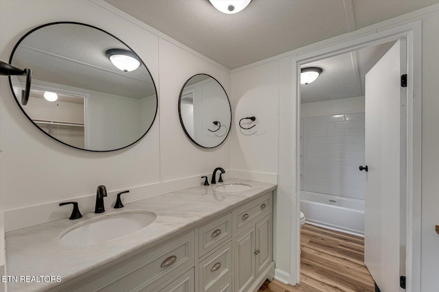 135 Mt View Rd, Sweetwater, TN 37874 - bathroom with double vanity, wood finished floors, a textured ceiling, and tub / shower combination