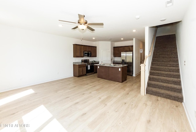 1334 Mountain Quail Cir, Maryville, TN 37801 - kitchen with stainless steel appliances, open floor plan, dark brown cabinets, light wood finished floors, and an island with sink
