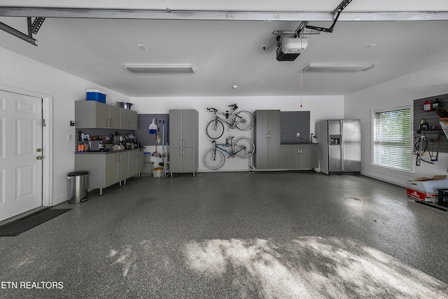 8940 Kelsey Ln, Knoxville, TN 37922 - garage featuring stainless steel fridge with ice dispenser and a garage door opener