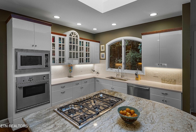 8940 Kelsey Ln, Knoxville, TN 37922 - kitchen featuring appliances with stainless steel finishes, recessed lighting, tasteful backsplash, glass insert cabinets, and light stone countertops