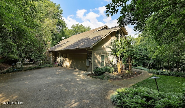 8940 Kelsey Ln, Knoxville, TN 37922 - view of home's exterior with asphalt driveway, an attached garage, a shingled roof, and a yard