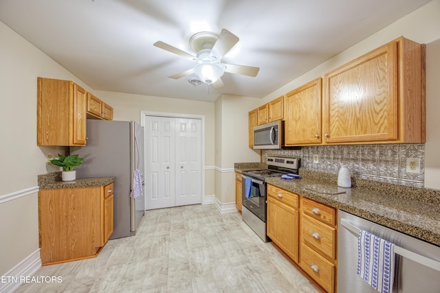 674 Applegate Ln Unit 32, Knoxville, TN 37934 - kitchen with stainless steel appliances, backsplash, baseboards, a ceiling fan, and dark stone counters