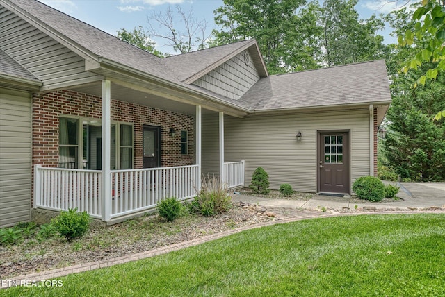 15 Chatham Ct, Fairfield Glade, TN 38558 - entrance to property with a porch, a lawn, a shingled roof, and brick siding