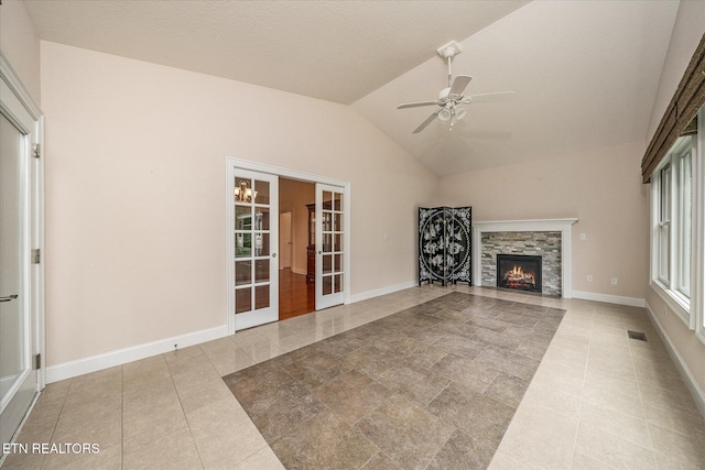 15 Chatham Ct, Fairfield Glade, TN 38558 - unfurnished living room with vaulted ceiling, a ceiling fan, a stone fireplace, french doors, and tile patterned floors