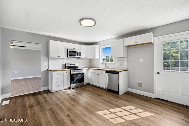 165 Kenzie Ln, Lafollette, TN 37766 - kitchen with appliances with stainless steel finishes, white cabinets, decorative backsplash, and a textured ceiling