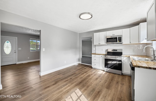 165 Kenzie Ln, Lafollette, TN 37766 - kitchen featuring appliances with stainless steel finishes, wooden counters, decorative backsplash, wood finished floors, and white cabinets