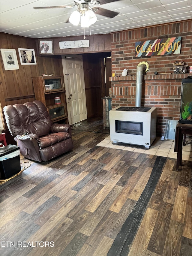2395 Howard Rd, Bybee, TN 37713 - living area featuring wood finished floors, a wood stove, ceiling fan, wood walls, and heating unit