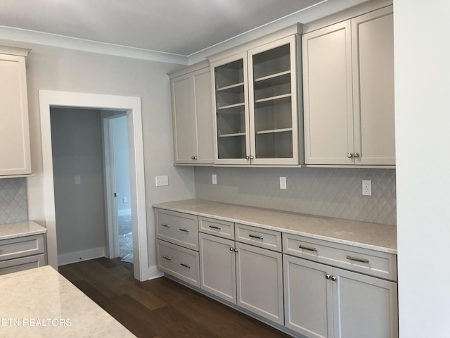 85 Royal Troon Cir, Oak Ridge, TN 37830 - kitchen featuring dark wood-style flooring, light countertops, decorative backsplash, glass insert cabinets, and ornamental molding