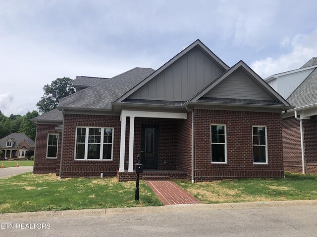85 Royal Troon Cir, Oak Ridge, TN 37830 - view of front of home featuring brick siding, board and batten siding, roof with shingles, and a front lawn