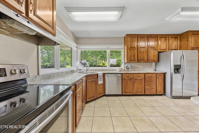 386 E Dr, Oak Ridge, TN 37830 - kitchen featuring stainless steel appliances, brown cabinetry, light stone countertops, and under cabinet range hood