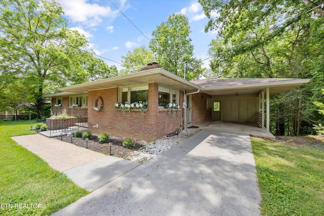 386 E Dr, Oak Ridge, TN 37830 - single story home with driveway, a front lawn, a carport, a chimney, and brick siding