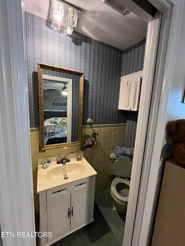 242 Adams Ln, Jellico, TN 37762 - half bathroom with wallpapered walls, vanity, tile walls, and wainscoting